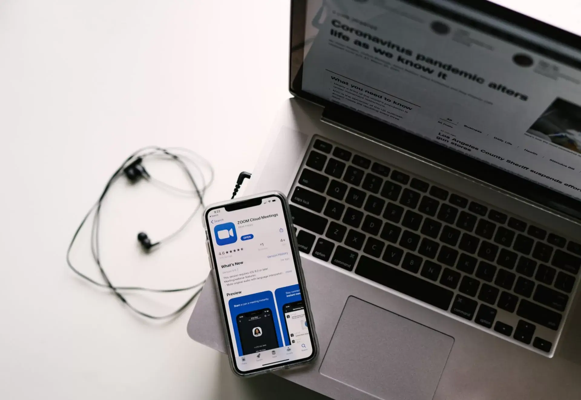 zoom meeting app on iphone near laptop and headphones