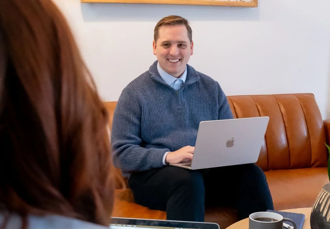 man on a laptop in a meeting with another person