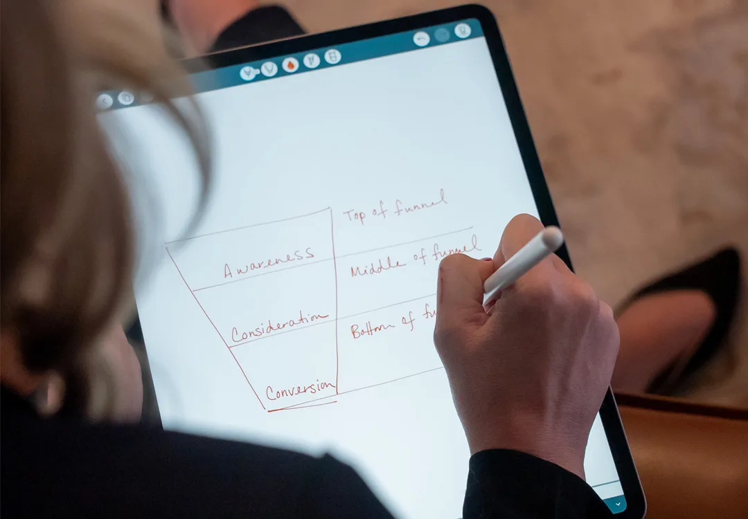 close up of a person drawing a funnel graphic on their tablet