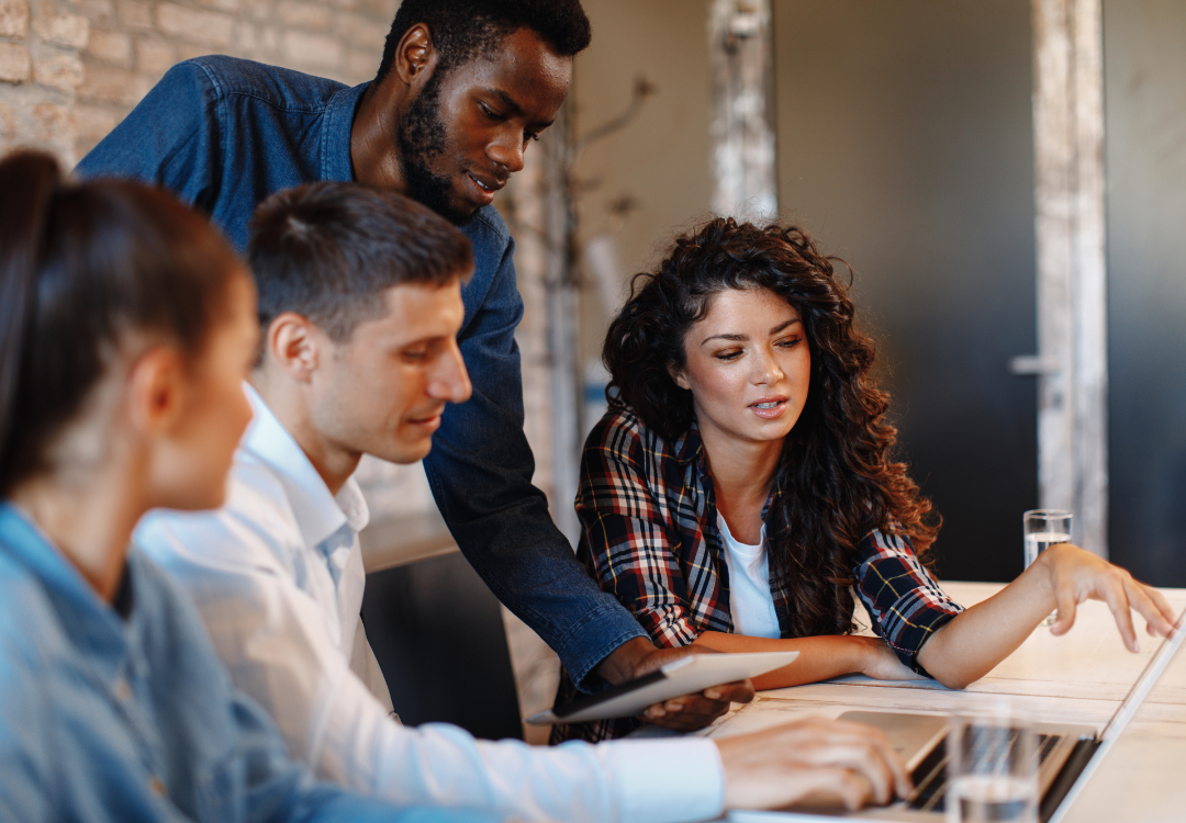 group of people working together near laptop