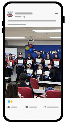 A group of people in uniforms stand and sit, holding certificates and smiling, in a decorated room with balloons and a "Congratulations!" banner, displayed on a phone screen as a social media post.